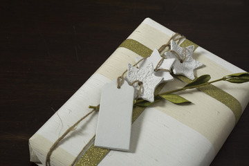 gift box with handmade, gold ribbon bow, and decorative white st