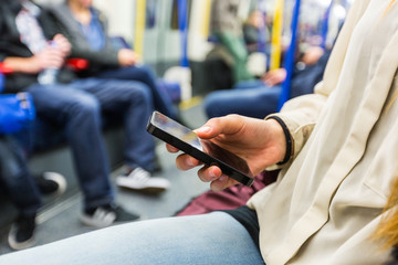 Young Woman Using Smart Phone in London Tube