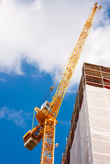 Construction crane next to a building with scaffolds