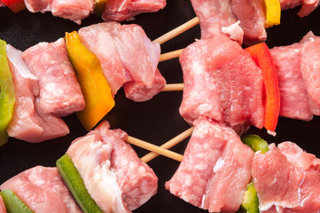Spiedini di carne di vitello crudi su un piatto