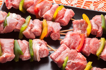 Spiedini di carne di vitello crudi su un piatto