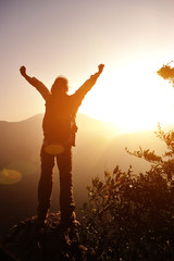 cheering woman hiker open arms at mountain peak 