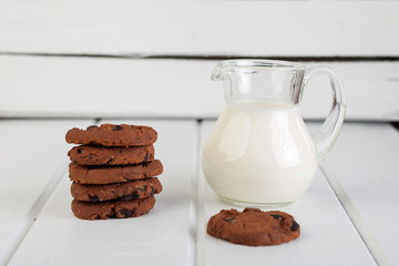 glass jug with milk and chocolate chip cookies