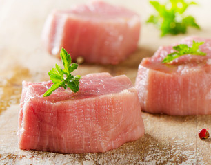 Raw beef with herbs on a wooden background.