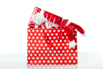 Red gift boxes and and christmas hat in shopping bags
