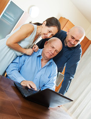 Obraz premium Three smiling people with laptop