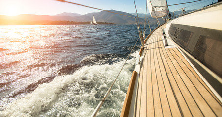 Yacht sailing towards the sunset. Sailing. Luxury yachts. - obrazy, fototapety, plakaty