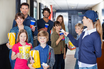 Worker Giving Tickets To Families At Cinema