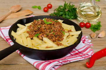Pasta with Bolognese ragout on a wooden table