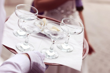 Waiter four glasses of champagne on table