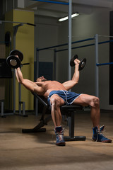 Fototapeta na wymiar Male Athlete Doing Heavy Weight Exercise For Chest