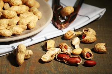 Peanuts on plate, on wooden background