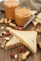 Bread slices with creamy peanut butter on wooden table