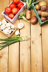 Different vegetables in boxes on wooden background top view