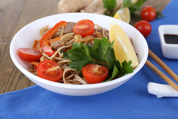 Chinese noodles with vegetables and roasted meat in bowl