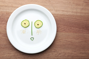 Vegetable face on plate on wooden table