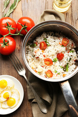 Tasty rice in pan on wooden table