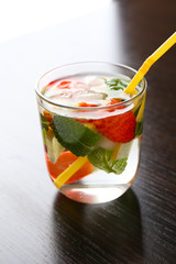 Summer cocktail with ice cubes on wooden table