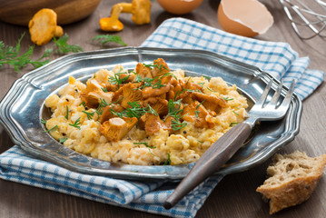 scrambled eggs with chanterelles and herbs on plate, horizontal