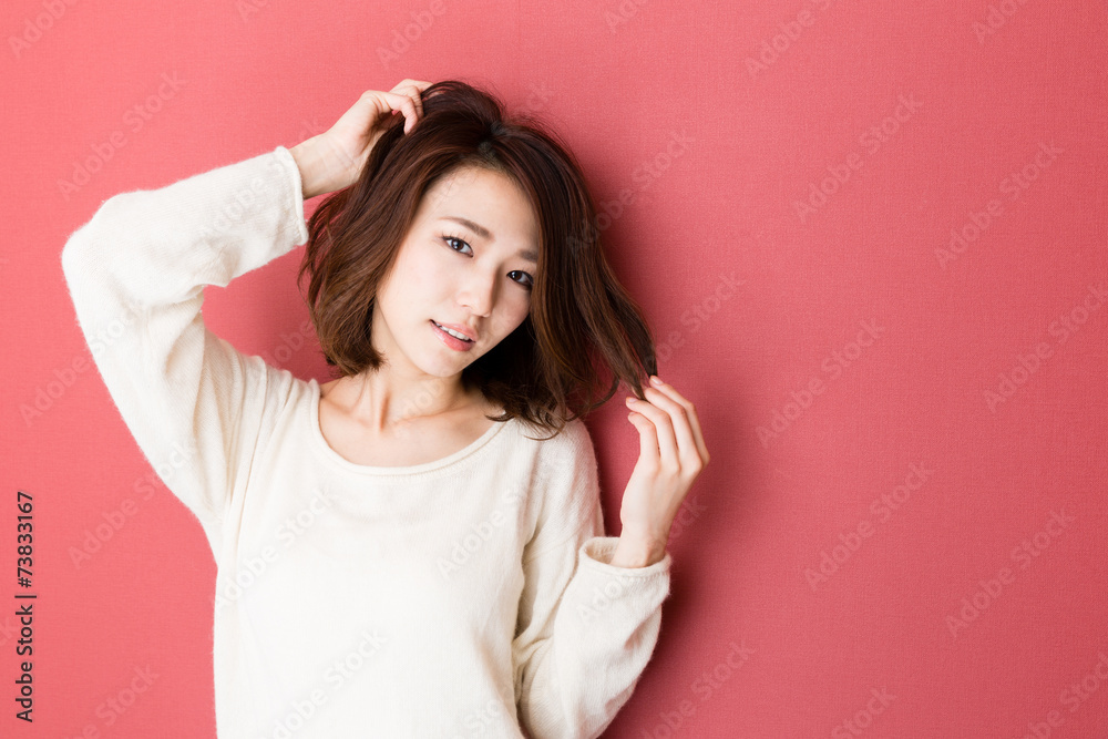 Wall mural attractive asian woman on red background