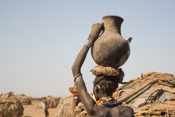 Woman carries on her head a container with water, Ethiopia - obrazy, fototapety, plakaty