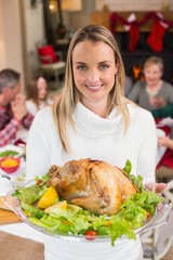 Obraz na płótnie Canvas Portrait of a smiling woman showing the roast turkey
