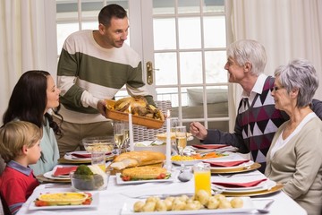 Man serving and showing roast turkey at christmas