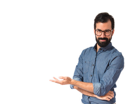 Young hipster man presenting something over white background