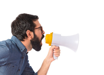Young hipster man shouting by megaphone