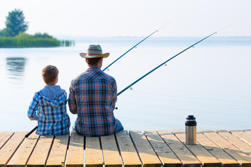 boy and his father fishing togethe - obrazy, fototapety, plakaty