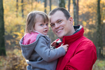Father and daughter in autumn forest