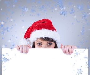 Composite image of festive brunette holding a poster