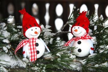 Two smiling snowmen friends on fir-tree