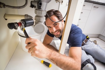 Plumber fixing under the sink