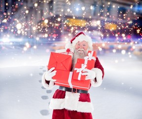 Composite image of santa carrying gifts in the snow