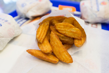 Appetizing slices of french fries on the table in  cafe