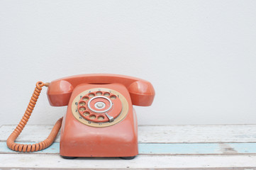 Retro orange telephone on wood table
