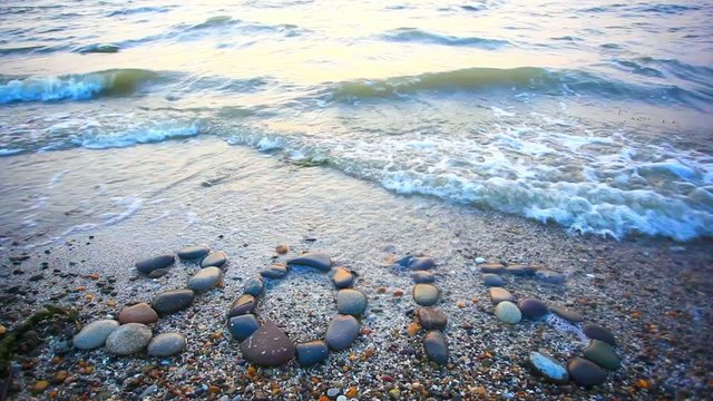 Christmas 2015 made of small stones on the sandy beach. HD.