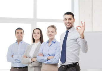 smiling businessman showing ok-sign in office