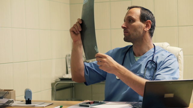 Male doctor checking and looking at xray in hospital