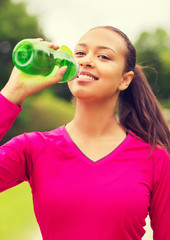 smiling woman drinking from bottle