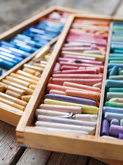 Fototapeta na wymiar Multicolored professional artistic pastel crayons in open wooden