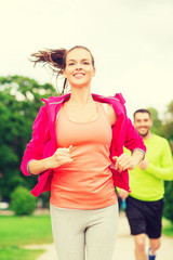 smiling couple running outdoors