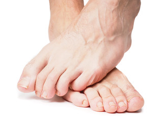 Male feet on over the other isolated towards white - obrazy, fototapety, plakaty