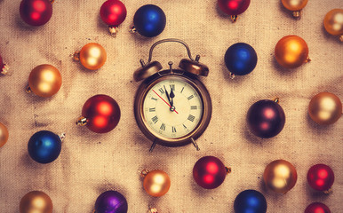 Retro alarm clock with gold, blue and red balls on jute backgrou