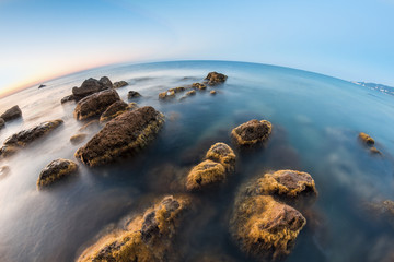 Underwater rocks at sunrise on beach