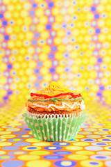 Delicious birthday cupcake on bright background
