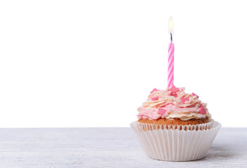 Delicious birthday cupcake on table on white background