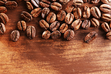 Coffee beans on wooden background, close-up