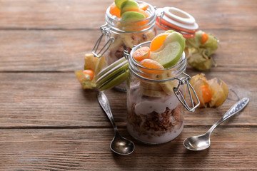 Healthy layered dessert with muesli and berries on table